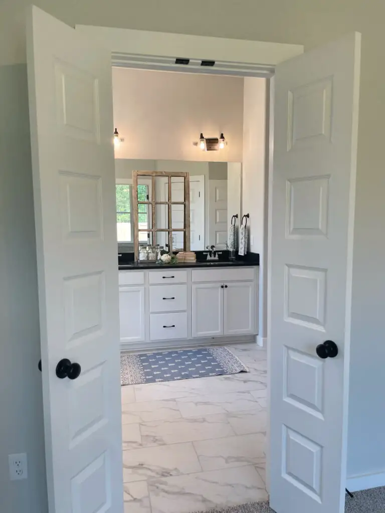 Update builder-grade bathroom with black matte hardware on white cabinets and doors