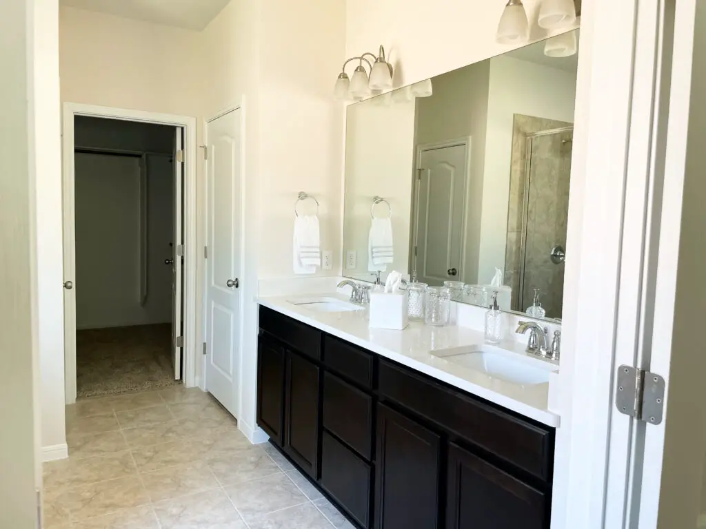 black double vanity with white countertop and grey tile floors