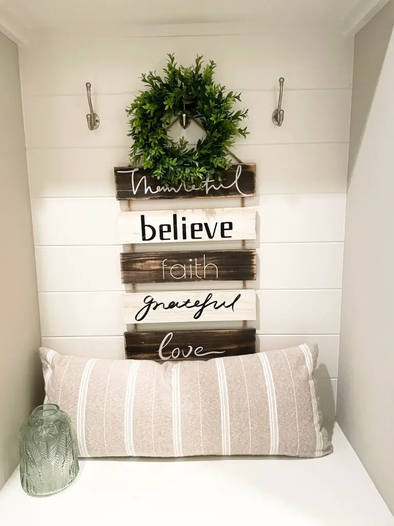 hanging word sign above white mudroom bench