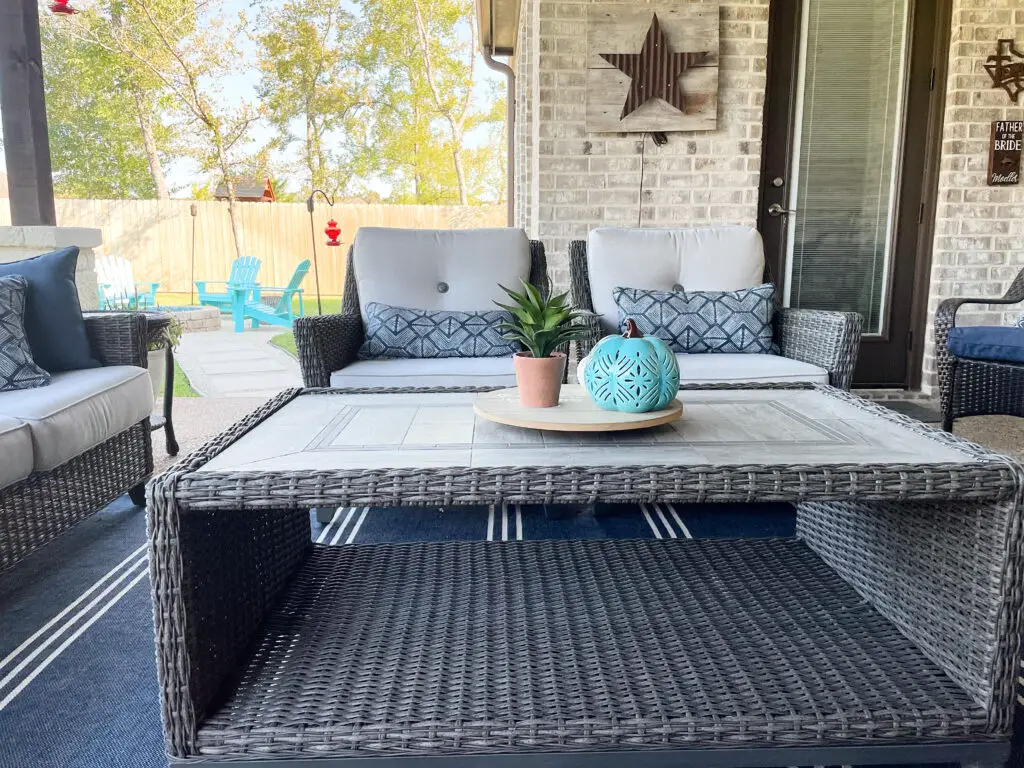 wicker patio chairs in front of wicker coffee table with a tile top