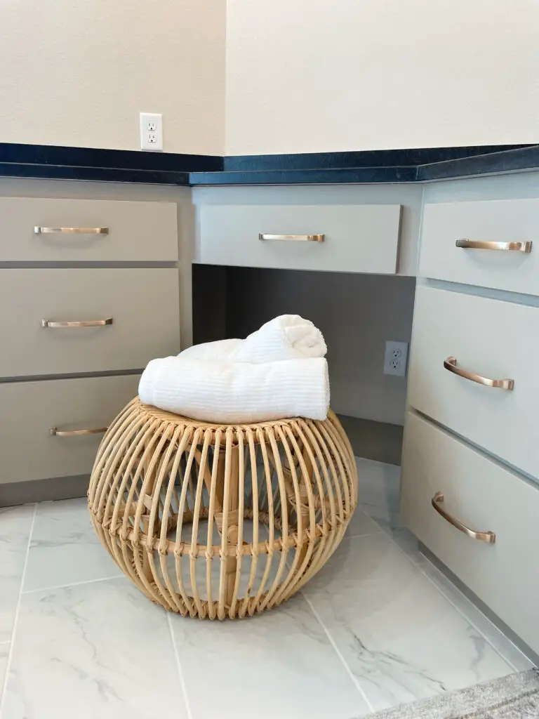bamboo pouf in bathroom with two white towels rolled up