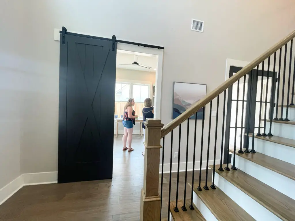 black barn door in entryway with art piece to the right of it