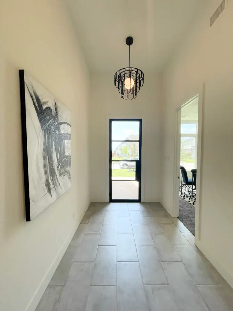Large artwork and black chandelier in entryway