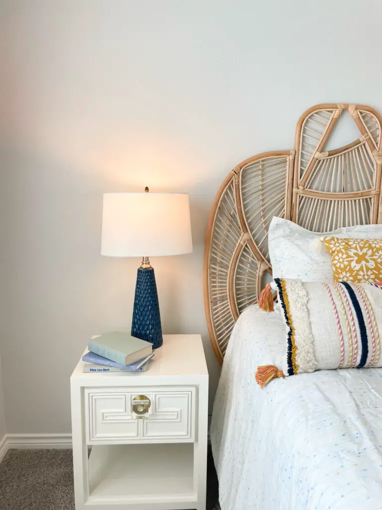 Blue textured lamp on glam nightstand with book stack