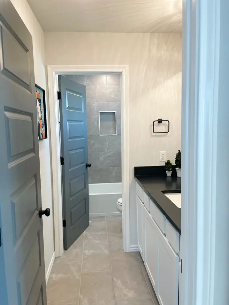Grey doors in bathroom with black knobs