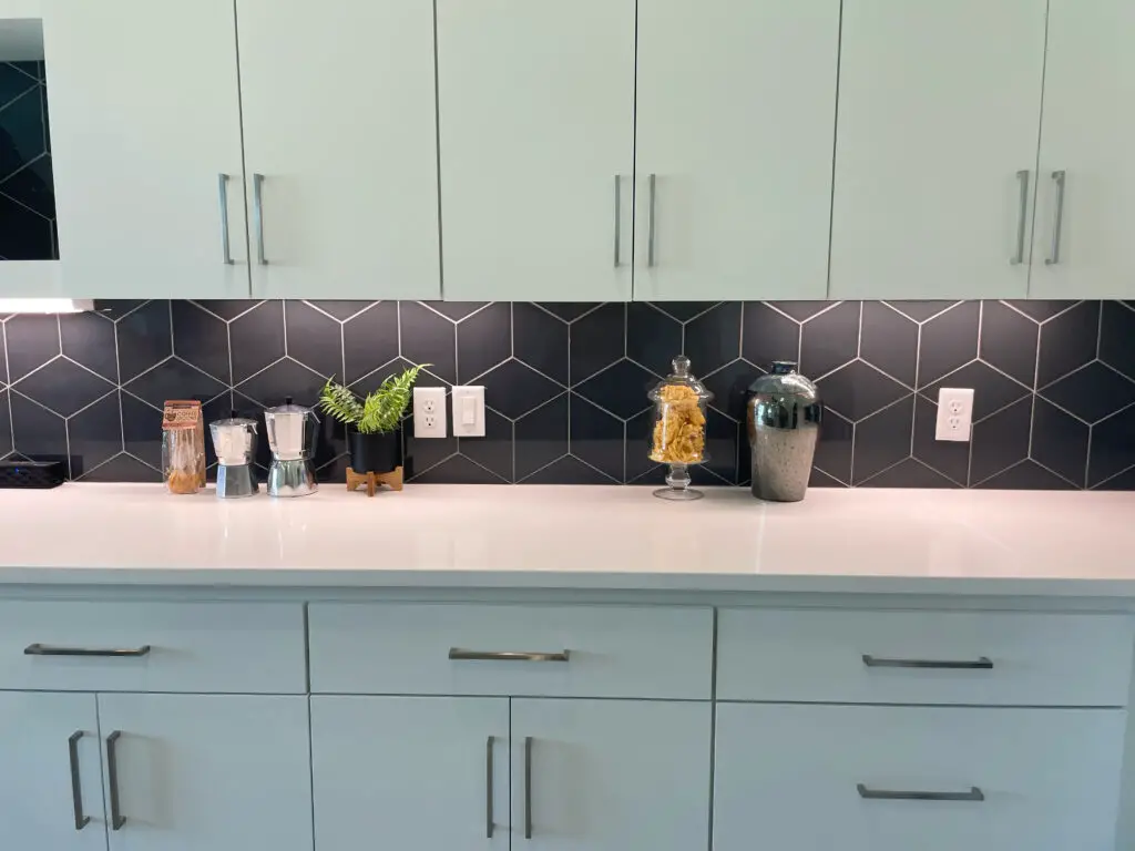 modern kitchen with grey cabinets and bold black backsplash