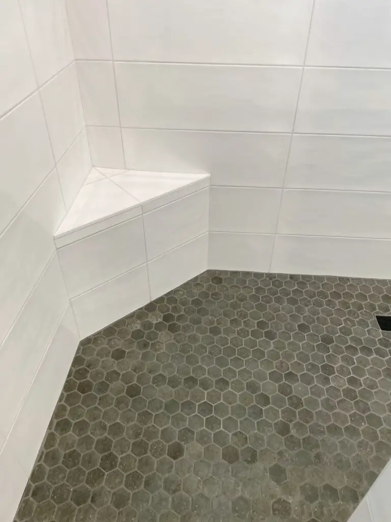 small grey tile floor with large white tile walls
