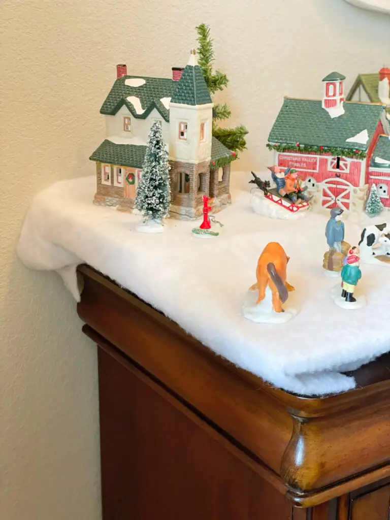 house on hill in Christmas village with characters and animals