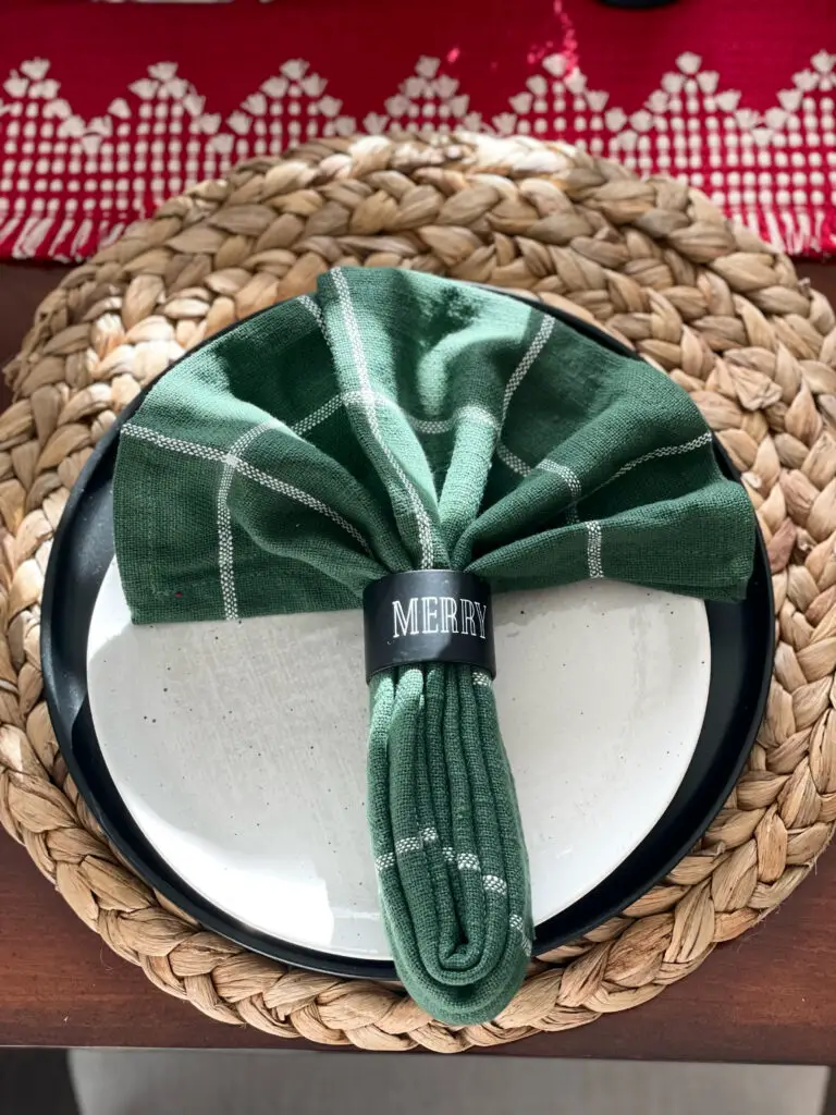 everyday decor on table with a green and white Christmas napkin and holiday napkin ring
