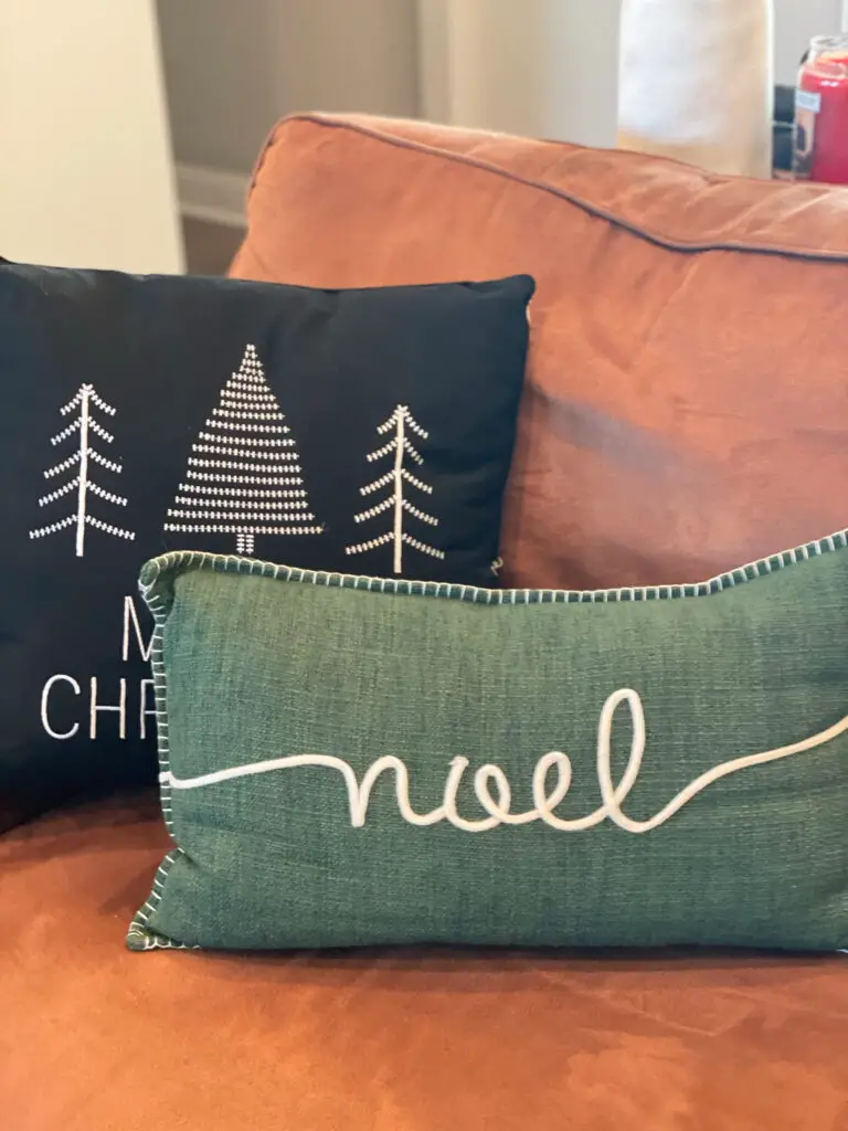 Black and green Christmas pillows on a couch