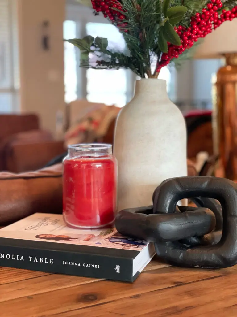 red Christmas candle in farmhouse display on sofa table