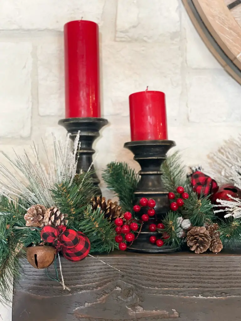 Red candles on black rustic candlesticks on fireplace mantel