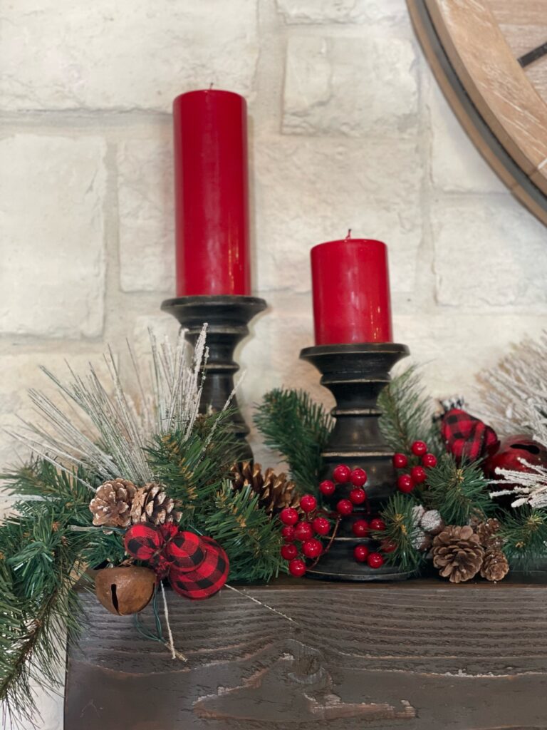 red candles on fireplace mantle in Christmas decorations