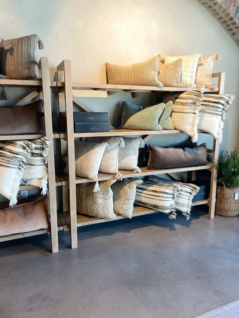 textured pillow display on oak shelves in store