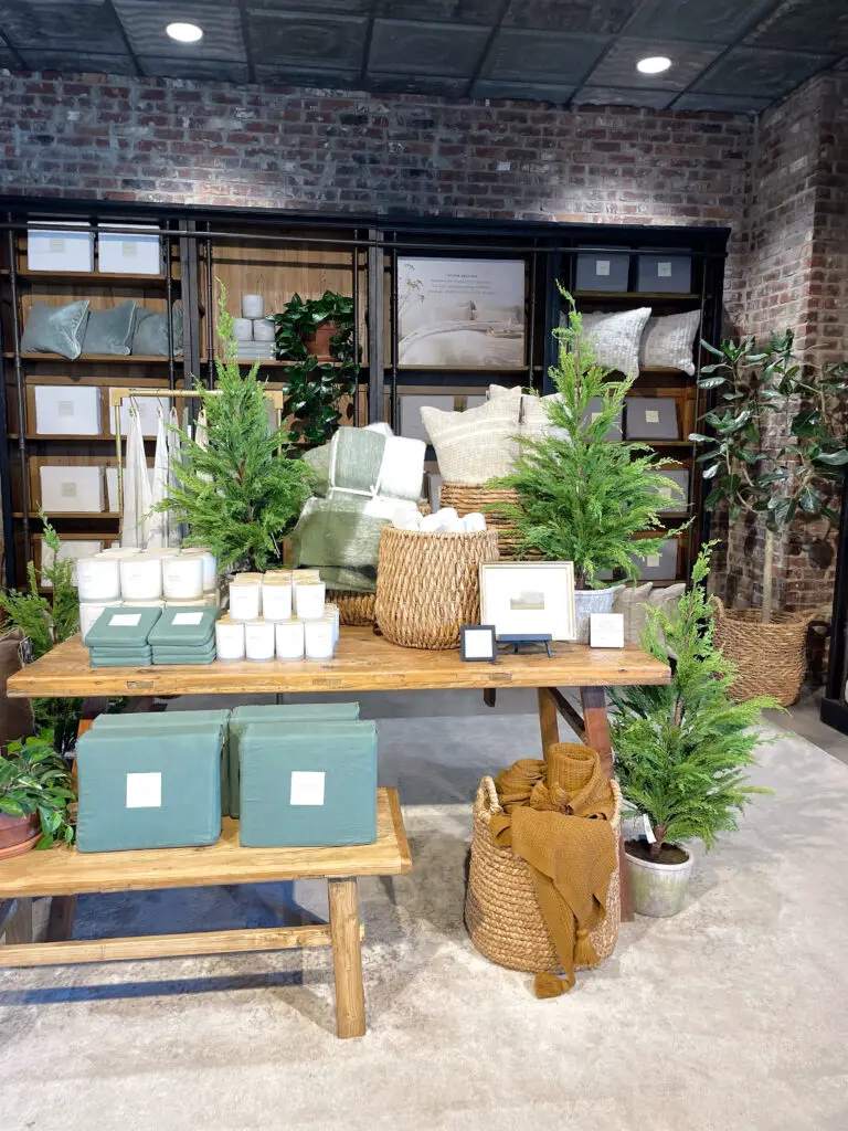 Wicker basket, linens and greenery display in store
