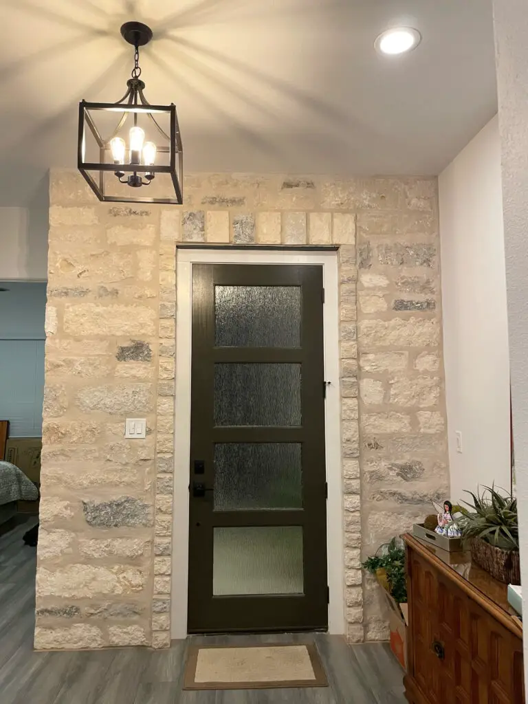 raw stone wall with medieval style light fixture in entryway