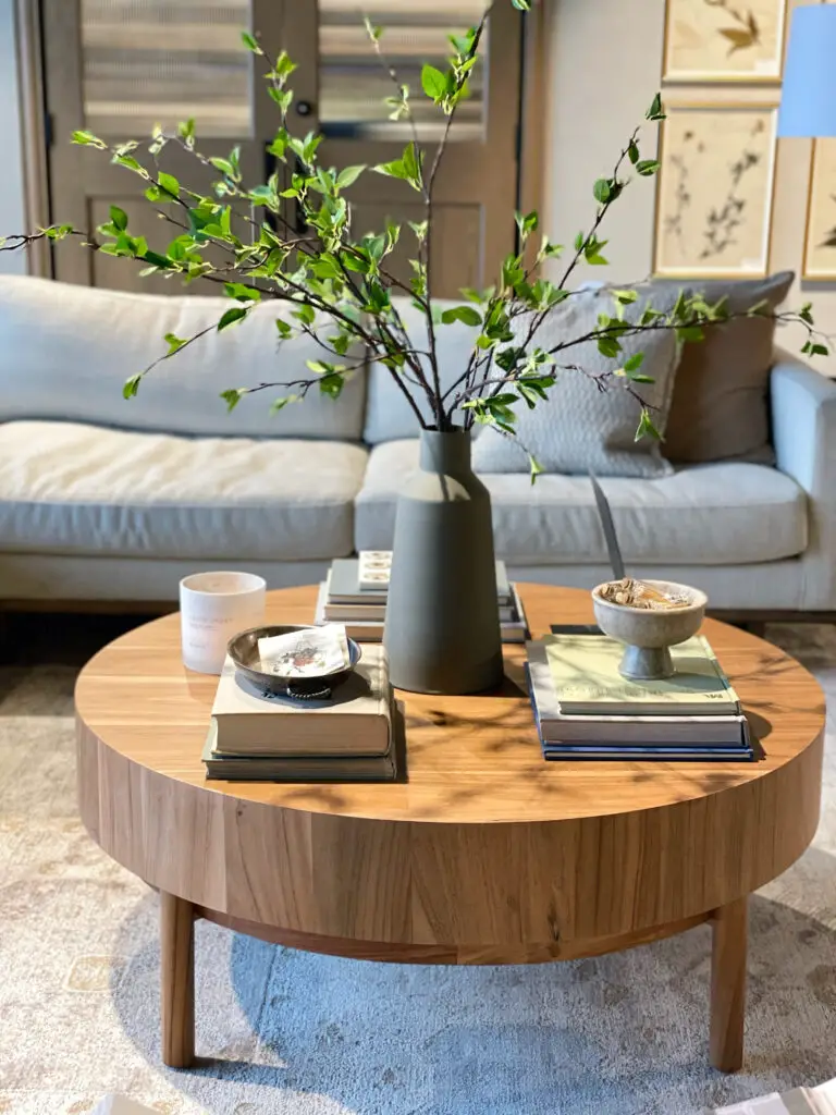 coffee table decorated with a vase, books, and decorative bowls