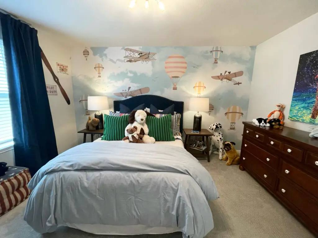 kid's bedroom with colorful accent wallpaper filled with planes and hot air balloons